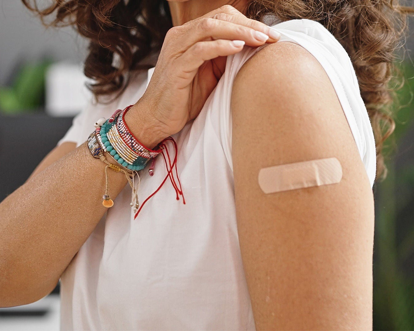 woman pulling up her sleeve to show a band aid on her arm