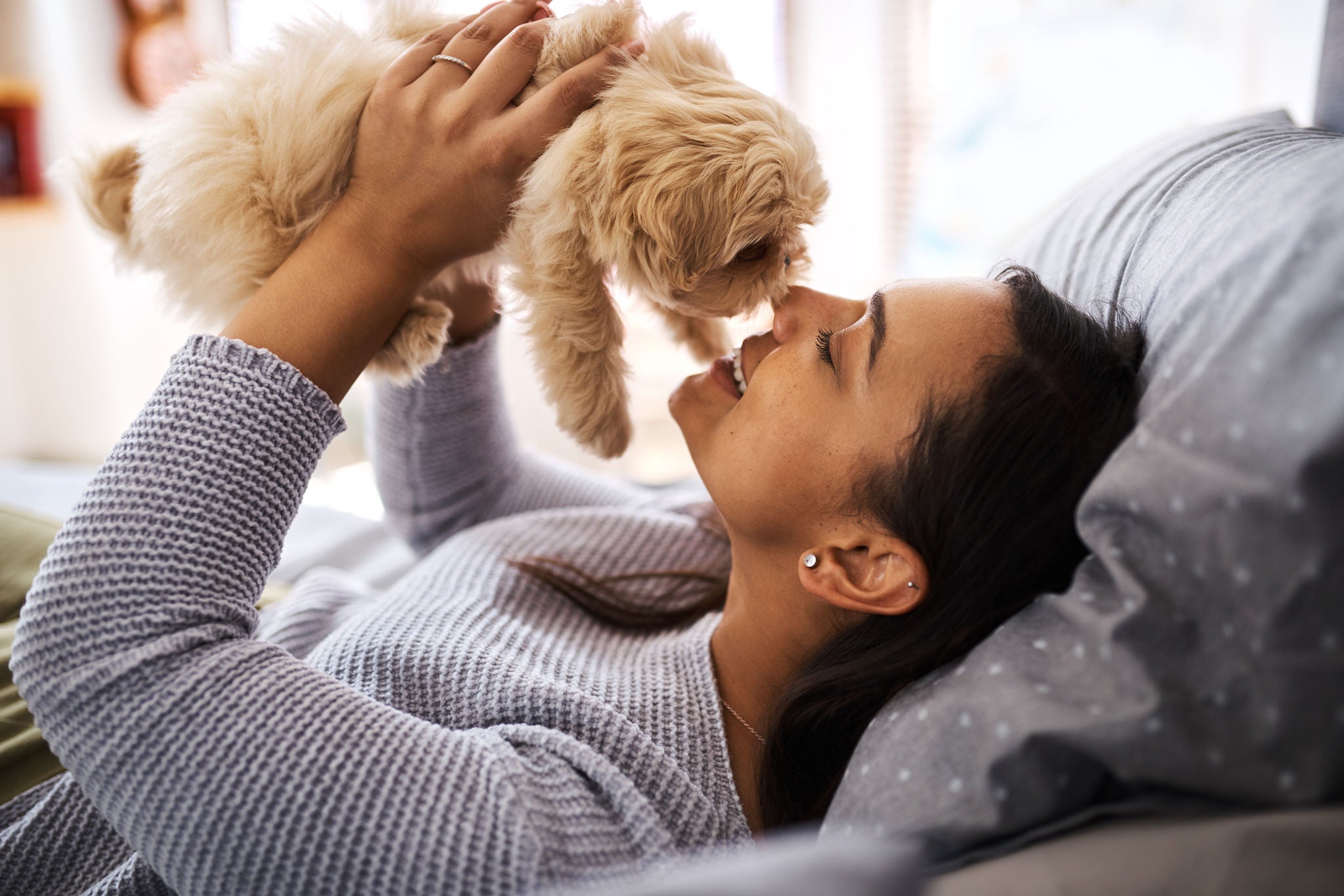 Shot of a young woman relaxing with her dog at home.