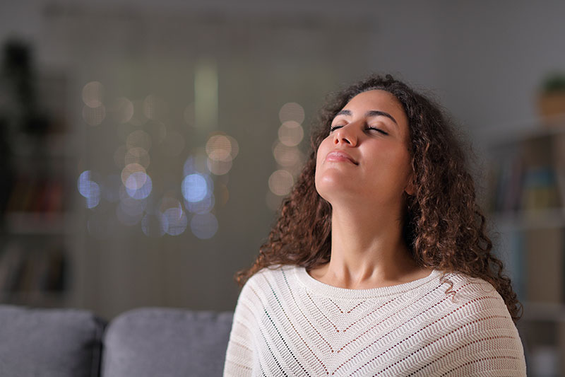 Woman spends time deep breathing and meditating.