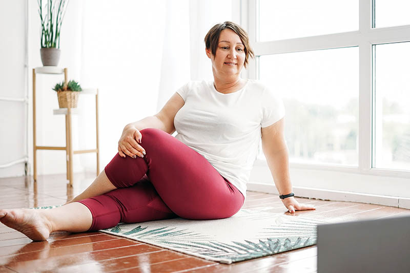 Adult woman practicing yoga at home to improve her bone health. 
