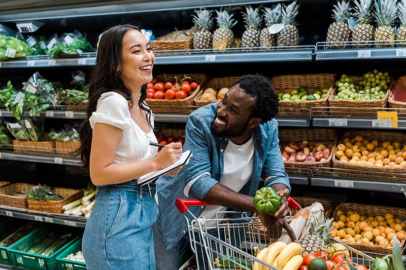 Couple shopping at the grocery store for fruits and vegetables.