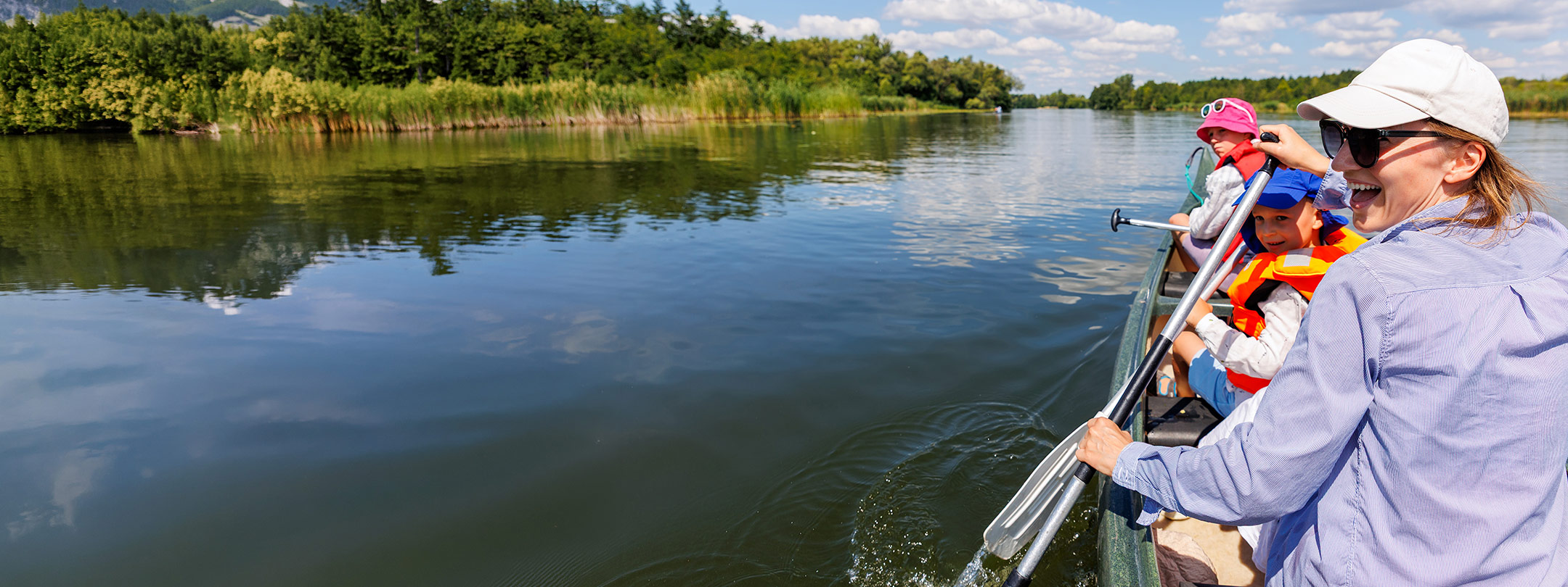 Happy family canoeing through a lake