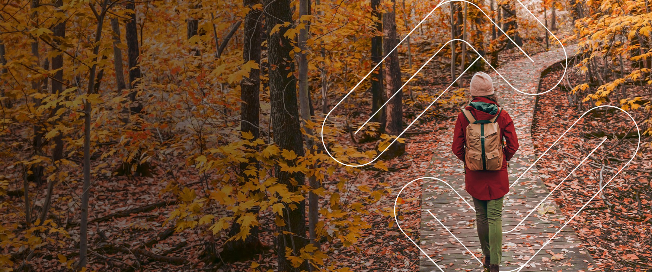 Person hiking through autumn forest trail