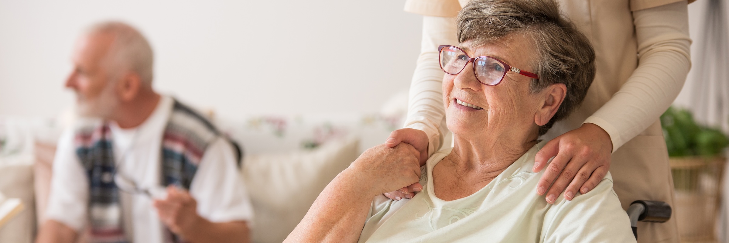 elderly woman with caretaker shaking hands with eachother