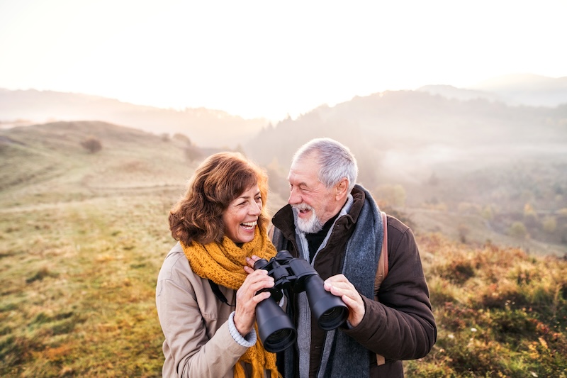 Older couple looking through binoculars together