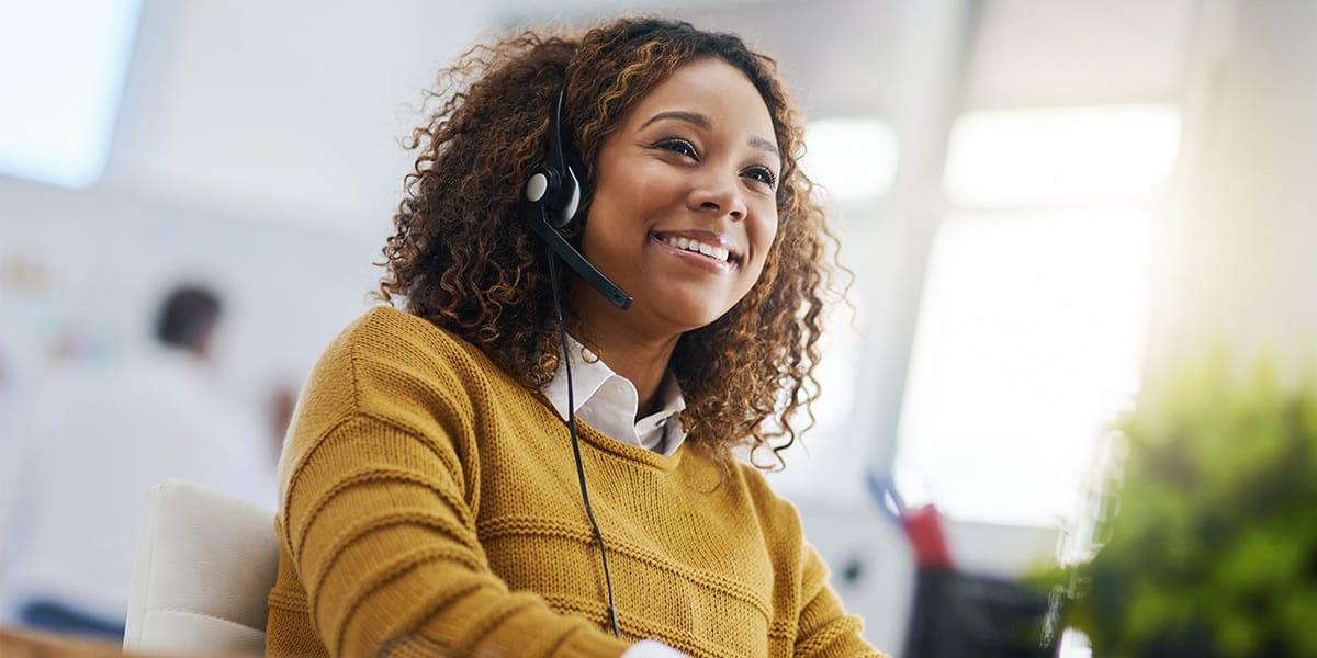 a female customer service representative wearing a headset smiling