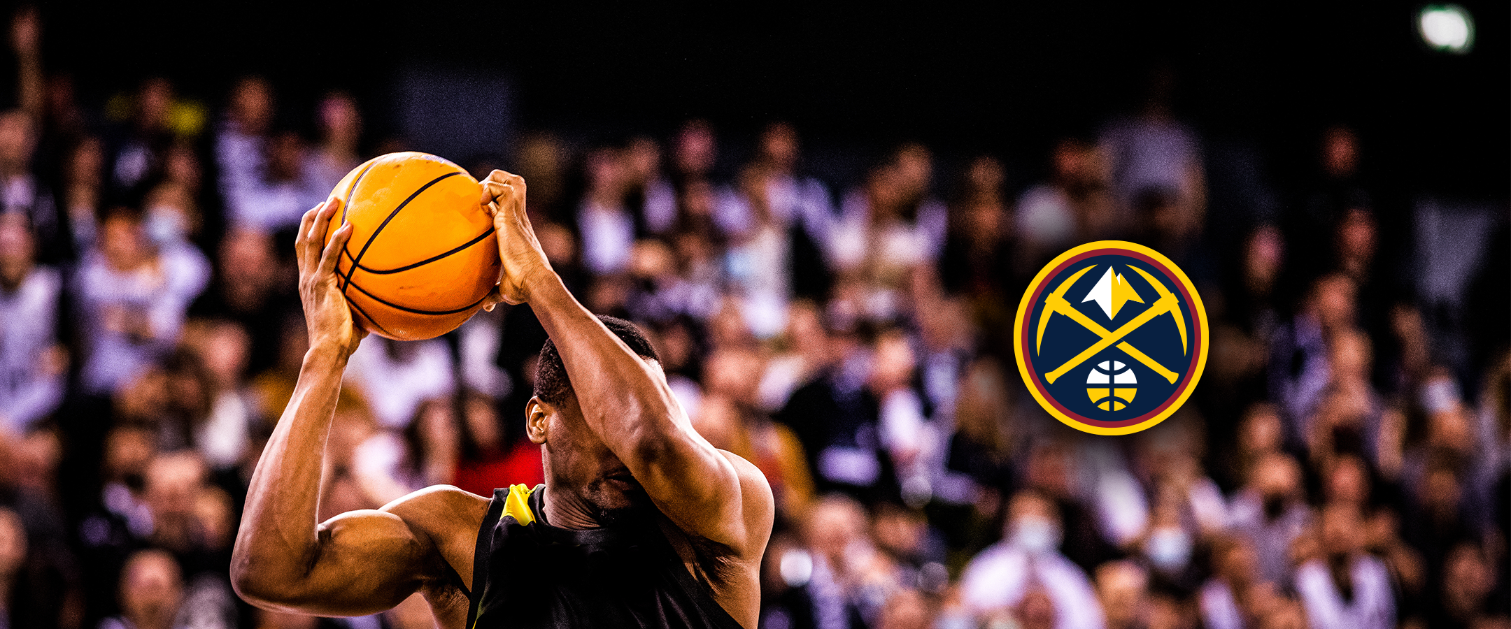 Basketball player shooting in crowded arena