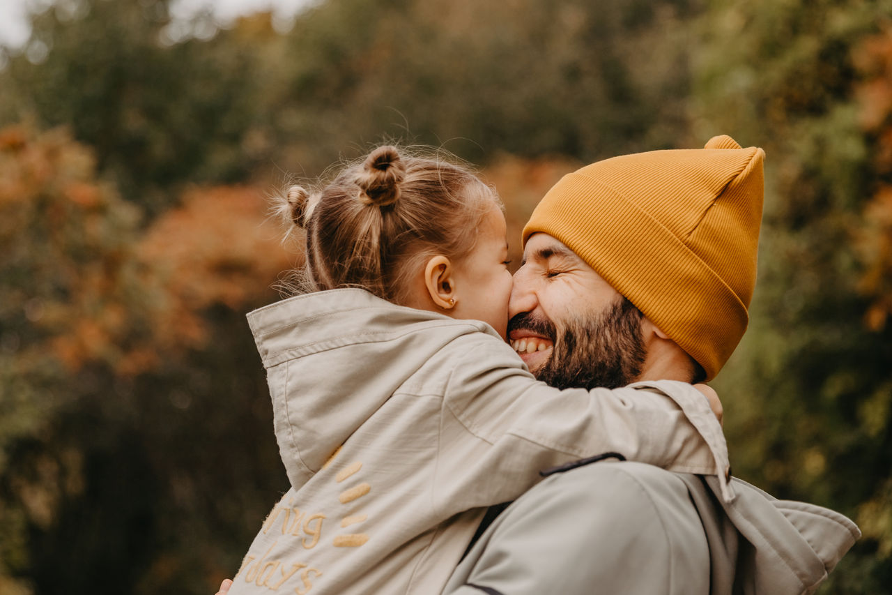 Happy father and daughter playing while walking in a beautiful autumn park. Ideal weekend father with his little daughter, autumnal mood