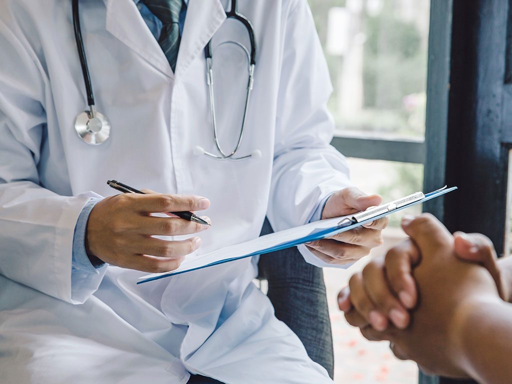 Doctor reviewing paperwork on a clipboard
