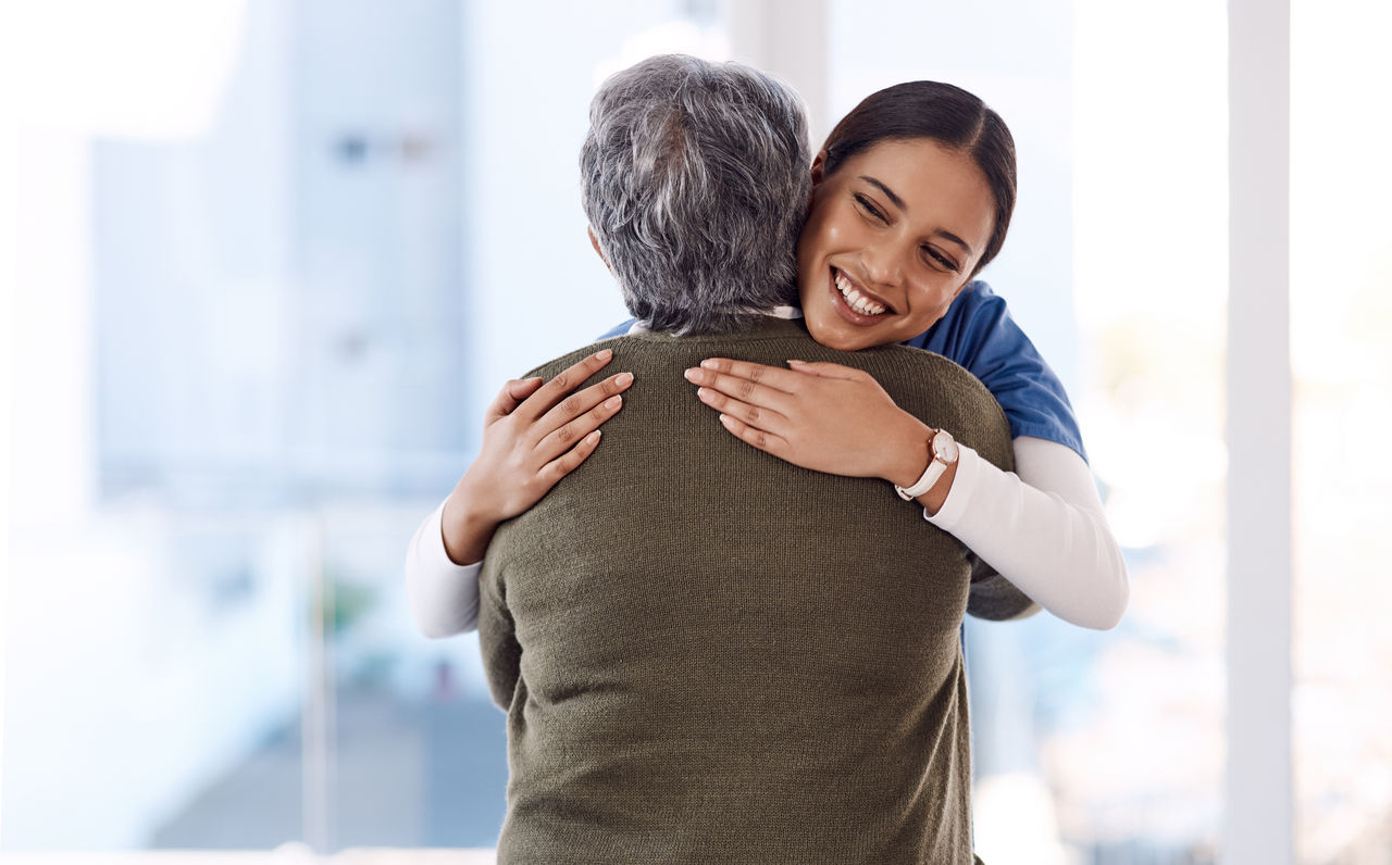 Healthcare, hug and nurse with senior woman, care and diagnosis with positive news, help and happiness. Female person, employee or medical professional with patient, lady and embrace for consultation.